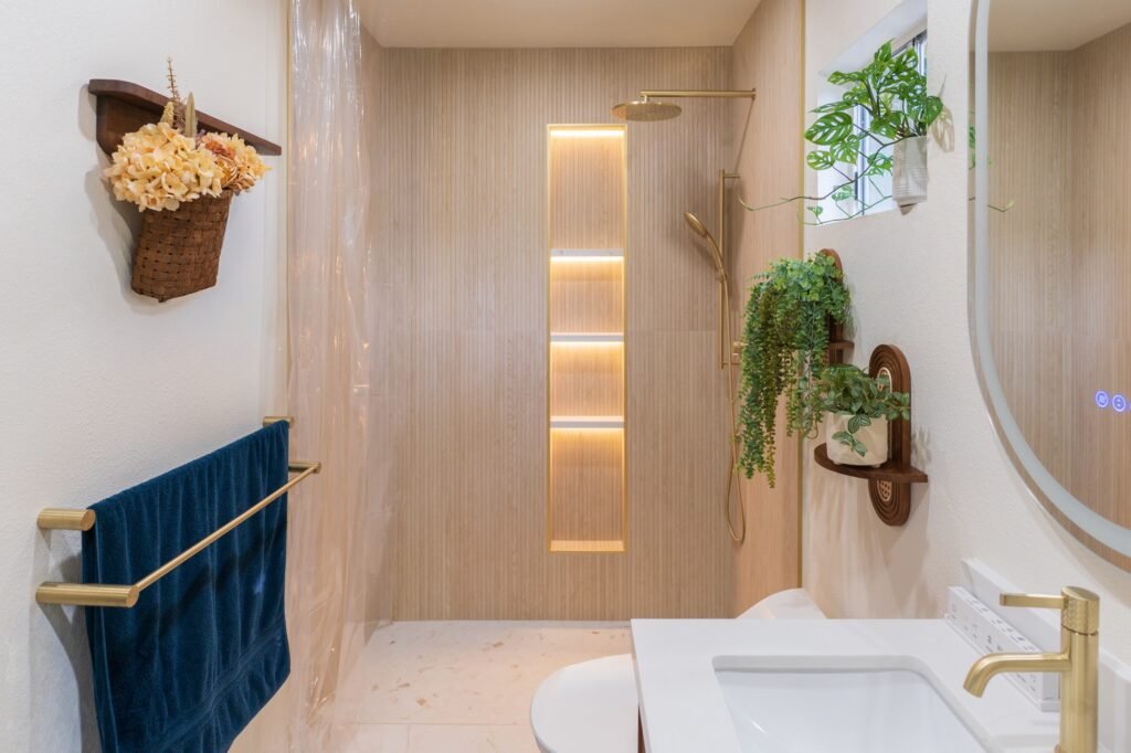 Remodeled Santee bathroom with fluted wood-look tile, brushed brass fittings and a backlit shower niche